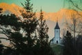 Fantastic charming Saint Primoz church on a small hill with colorful mountain backdrop in background at sunset, Jamnik village, Royalty Free Stock Photo