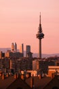 Fantastic cityscape of Madrid with sunlit modern high-rise buildings and TV tower at twilight