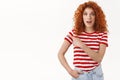 Fantastic deal check out. Amused good-looking redhead curly stylish girl wearing striped t-shirt discuss awesome promo