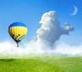 Fantastic dreams. Hot air balloons in blue sky with clouds and crescent moon over misty green meadow Royalty Free Stock Photo