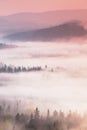 Fantastic dreamy sunrise on the top of the rocky mountain with the view into misty valley Royalty Free Stock Photo