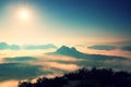 Fantastic dreamy sunrise on the top of the rocky mountain with the view into misty valley Royalty Free Stock Photo