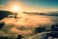 Fantastic dreamy sunrise on the top of the rocky mountain with the view into misty valley Royalty Free Stock Photo