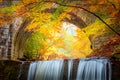 Fantastic Fall Autumn landscape - river waterfall in colorful autumn forest park with yellow red leaves with old bridge Royalty Free Stock Photo