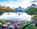 Fantastic landscape at sunrise with stones in the foreground on the lake in the Swiss Alps. Wetterhorn, Schreckhorn,