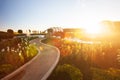 Fantastic landscape of tropical garden with fountain at sunset, bright sun setting with beautiful lens flare, tourists relaxing Royalty Free Stock Photo