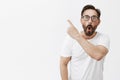 Fantastic, look. Portrait of amazed and impressed handsome adult man with beard and wrinkles in glasses, pointing at
