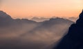 Fantastic misty morning in the dolomites Alps. landscape with colorful misty silhouettes of mountains with rays . Nature Royalty Free Stock Photo