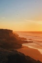 Fantastic orange sunset with a lot flying birds. Layered coastline near Agadir