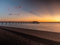 Fantastic patterns in the sky caused by the light during sunrise over Deal Pier