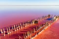 A fantastic pink-orange salt lake with salt crystals on wooden pillars. Shooting from a drone. Copy space. Royalty Free Stock Photo
