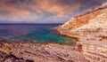 Fantastic rocky beach coastline during sunset. impressively beautiful seascape with picturesque sky over calm blue ocean under Royalty Free Stock Photo