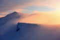 Fantastic scenery with a free rider and mountaineer, high mountains in snow and the fog with interesting colour from the sun. Royalty Free Stock Photo