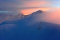 Fantastic scenery with a free rider and mountaineer, high mountains in snow and the fog with interesting colour from the sun. Royalty Free Stock Photo