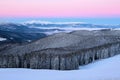 Fantastic scenery with the high mountains in snow, dense textured fog and a sunrise in the cold winter day. Royalty Free Stock Photo