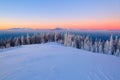 Fantastic scenery with the high mountains in snow, dense textured fog and a sunrise in the cold winter day. Royalty Free Stock Photo