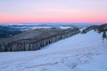 Fantastic scenery with the high mountains in snow, dense textured fog and a sunrise in the cold winter day. Royalty Free Stock Photo