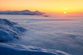 Fantastic scenery with the high mountains in snow, dense textured fog and a sunrise in the cold winter day. Mountains in fog. Royalty Free Stock Photo