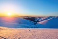 Fantastic scenery with the high mountains in snow and a sunrise in the cold winter day.