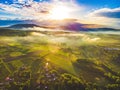 Fantastic shot of farm fields covered in early morning fog during sunrise