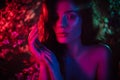 A fantastic shot of a girl in flowers with neon multicolored light and phantasmagoria. The concept of fantasy, fairy Royalty Free Stock Photo