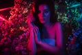 A fantastic shot of a girl in flowers with neon multicolored light and phantasmagoria. The concept of fantasy, fairy Royalty Free Stock Photo