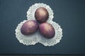 3 fantastic space cosmic purple marble eggs on paper napkins and black slate board. Copy space. Top view