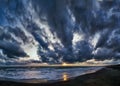 Fantastic stormy sky and dramatic weather panoramic view over the beach , impressive blue hour with golden sunbeams hits rough Royalty Free Stock Photo