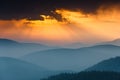 Fantastic sunrise above peaks of smoky mountain with the view into misty hills. Royalty Free Stock Photo