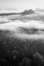 Fantastic sunrise on the top of the rocky mountain with view into misty valley. Black and white Royalty Free Stock Photo