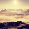 Fantastic sunrise on the top of the rocky mountain with the view into misty valley Royalty Free Stock Photo