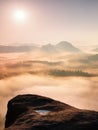 Fantastic sunrise on the top of the rocky mountain with the view into misty valley Royalty Free Stock Photo