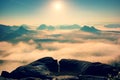 Fantastic sunrise on the top of the rocky mountain with the view into misty valley Royalty Free Stock Photo