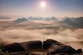 Fantastic sunrise on the top of the rocky mountain with the view into misty valley Royalty Free Stock Photo