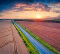 Fantastic sunrise on Ukrainian countrysidewith asphalt road among the field of wheat. Royalty Free Stock Photo