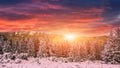 Fantastic sunset in the mountains landscape. colorful overcast clouds over the snow covered pines glowing in sunlight . Royalty Free Stock Photo