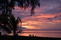 Fantastic sunset on a tropical  beach with silhouette of people enjoying that magical moment. Royalty Free Stock Photo