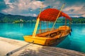 Wooden Pletna boat on the lake Bled with small island