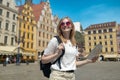 Fantastic view of the ancient homes on a sunny day. Woman with city map and smart phone. Gorgeous and picturesque scene