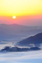 Fantastic view of the mountain peaks in the fog and the rising sun over the mountains.