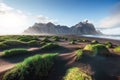 Fantastic west of the mountains and volcanic lava sand dunes on the beach Stokksness, Iceland. Colorful summer morning