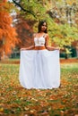 Fantastic young woman. beautiful fantasy girl fairy with white long dress in windy autumn park Royalty Free Stock Photo