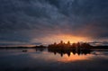 Fantastically beautiful summer sunrise over Trakai Castle in Lithuania, with lonely fisherman in the boat and the sun`s rays. Royalty Free Stock Photo