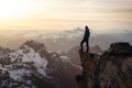 Fantasy Adventure Composite with a Man on top of a Mountain Cliff