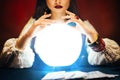 Fantasy beautiful retro women& x27;s hands close-up, look feel energy of crystal ball in dark gothic room. Photo of old art