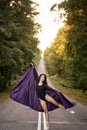 Fantasy Beautiful woman ballerina dancing on road. Summer nature background trees. Royalty Free Stock Photo