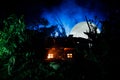 Fantasy decorated photo. Small beautiful house in grass with light. Old house in forest at night with moon. Selective focus Royalty Free Stock Photo