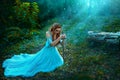 Fantasy elf woman princess warrior sits in forest on green grass holding weapon medieval sword in hands. Warlike queen Royalty Free Stock Photo