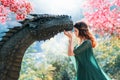 Fantasy female queen hugs and touches pet dragon with love like mother. Magic divine sun light summer nature flowering Royalty Free Stock Photo