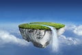 Fantasy floating island with river stream on green grass in blue sky Royalty Free Stock Photo